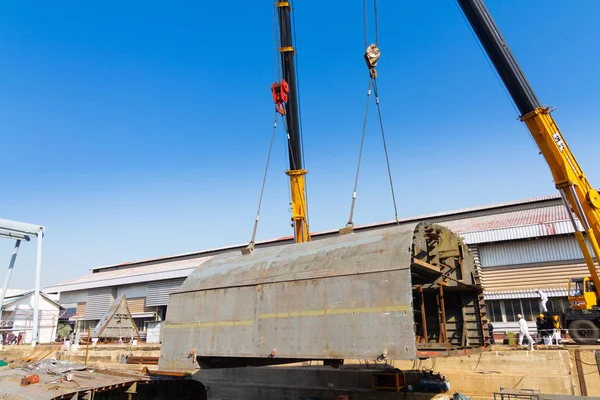 Kuru rıhtım üzerinde çalışan iki kamyon vinçler gemi gövde par kaldırıyor