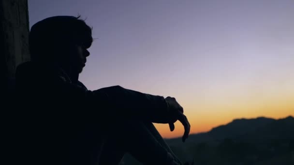 Adolescent Assis Fenêtre Coûteuse Avec Coucher Soleil Arrière Plan — Video