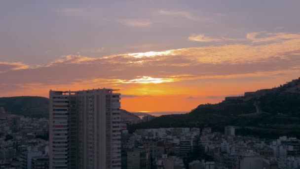 美しい山の街の風景は 背景に我々は海を参照してください オレンジと曇りの空 ヨーロッパの旅行 海と都市 スペイン アリカンテ — ストック動画