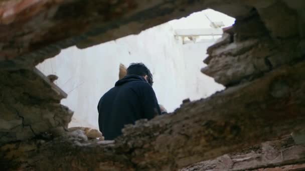 若い男 ティーンエイジャーは 放棄された家の梁の上に高く座って 彼のフードを置きます 若い悲しい うつ病 思慮深い 放棄されたサイト 危険の探検 スローモーション — ストック動画