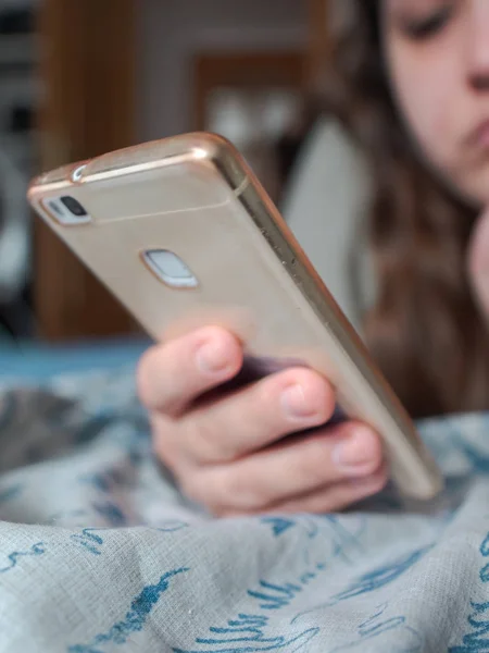 Adolescente Menina Parece Entediado Seu Telefone Celular Deitado Cama Imagens Royalty-Free