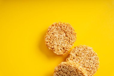 Sarı arkaplan üzerinde yuvarlak şekilli hazır erişte grubu. Üst görünüm.