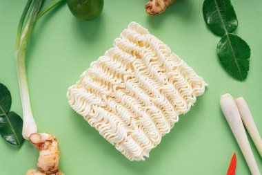 Üst Manzara - Tom Yum malzemeleriyle yeşil arkaplan üzerine anlık şehriye.