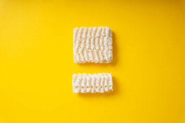 Sarı arka planda parçalanmış hazır erişte..