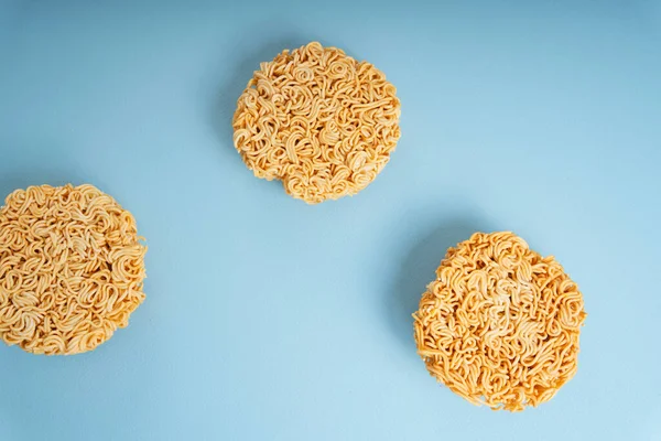 Group of circle shape instant noodle over blue background. Top view.