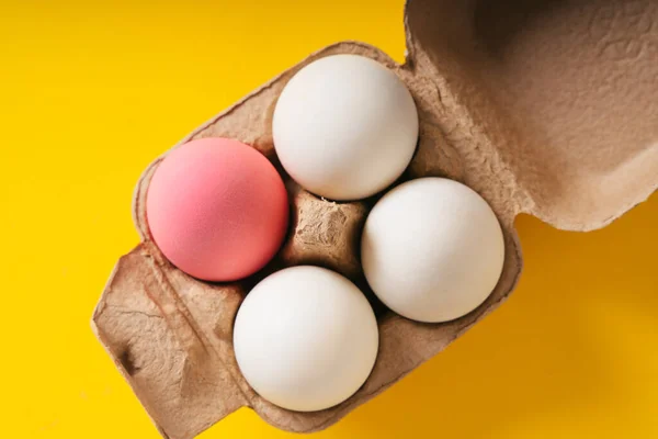 Top View One Pink Egg Three White Egg Box Yellow — Stock Photo, Image