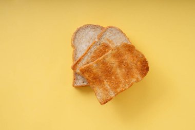 Üst Manzara - 4 tip ızgara yanmış ev yapımı organik dilimlenmiş ekmek sarı arkaplan üzerinde.