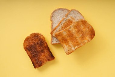 Üst Manzara - 4 tip ızgara yanmış ev yapımı organik dilimlenmiş ekmek sarı arkaplan üzerinde.
