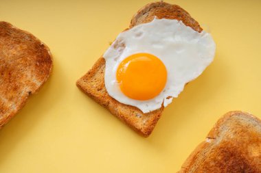 Üç ev yapımı organik ekmek ızgarası ve üstünde kızarmış yumurta..