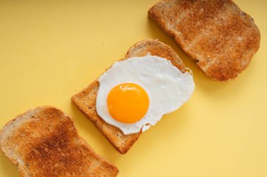 Üç ev yapımı organik ekmek ızgarası ve üstünde kızarmış yumurta..