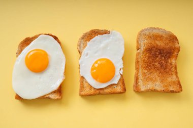 Üç ev yapımı organik ekmek ızgarası ve üstünde kızarmış yumurta..