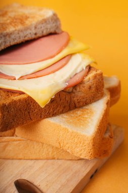 Yakın çekim - Tahta bloknotta salamlı peynir yığını.