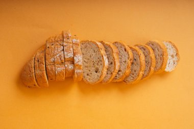 Üst Manzara - Turuncu arka planda dilimlenmiş somun ekmek.