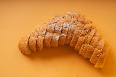 Üst Manzara - Turuncu arka planda dilimlenmiş somun ekmek.