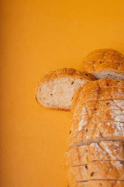 閉じる オレンジの背景にパンのスライス — ストック写真