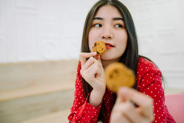 손으로 초콜릿 쿠키를 셔츠를 아름다운 아시아인의 — 스톡 사진