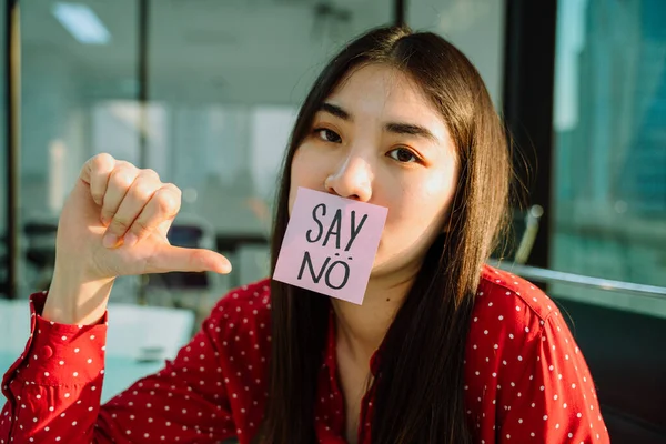 Kırmızı gömlekli güzel Asyalı iş kadını. Reddetmek ya da reddetmek. Kağıda hayır de. Vuruşlar.