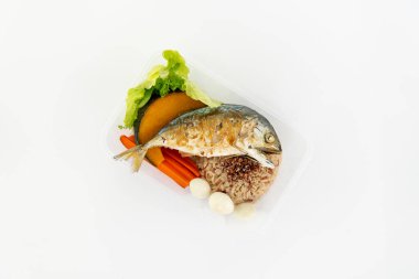 Bol yağda kızartılmış uskumru, pirinç ve haşlanmış sebzelerin olduğu bir kutu. Beyazla izole et.