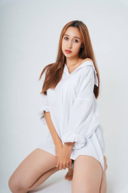 Beyaz gömlekli, doğal makyajlı güzel bir kadın beyaz arka planda izole edilmiş. Cilt bakımı. Uzun beyaz gömlekli seksi kadın. Portreyi kapat.