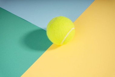 Üst manzara - yeşil mavi sarı kort kağıdında tenis topu. Spor konsepti.