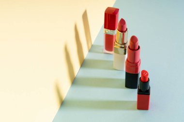 Pastel duvarda kırmızı ruj ürünü koleksiyonu.