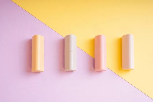 Kommerzielles Produkt Gruppe Pastellbeiger Lippenstifte Auf Gelbem Und Lila Hintergrund — Stockfoto