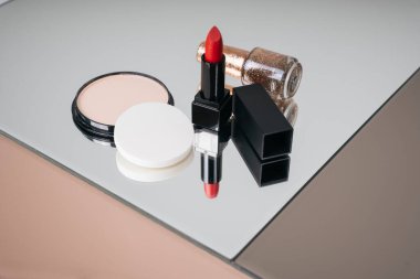 Mirrow masasında lüks kozmetik ürünleri. Kırmızı ruj kara kutu ve pudra pudrası..