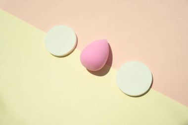 Kozmetik aletler uydur. Pudra ponponu iki ton sarı ve pembe renkte izole edilir. Komik surat..