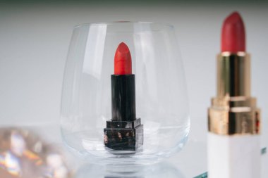 Altın rengi kırmızı ve pembe ruj ve ayna masasında siyah sürgü. Siyah olan cam kaseyle kaplanmış. Kozmetik konteynır. Lüks ruj..