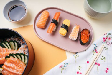 Üst manzara - Japon suşi seti ve soya soslu somon balığı ve çay fincanı..