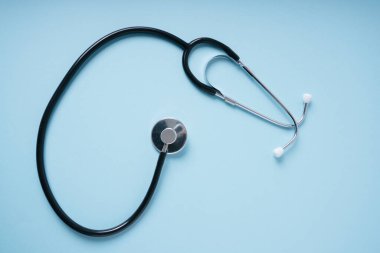 Stetoskop doktoru kliniği mavi arka plan üzerinde çalışıyor..