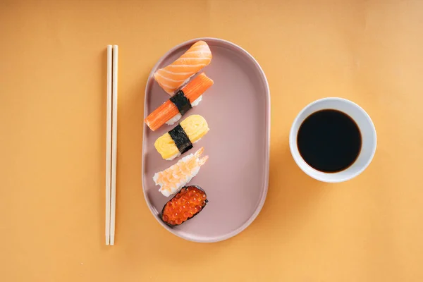 日本寿司与寿司酱油和筷子放在盘子里 — 图库照片