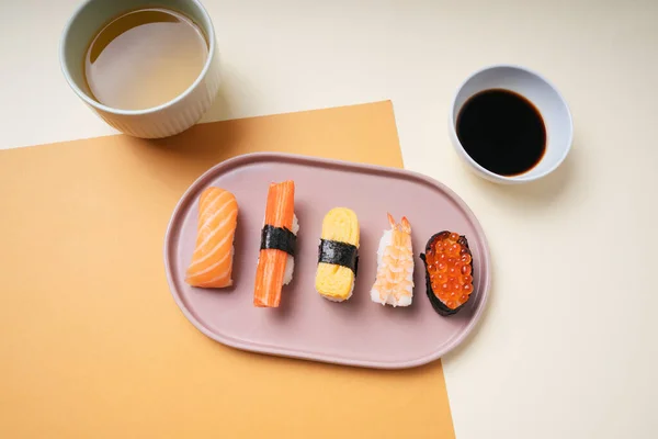 顶部视图 日本寿司与酱油和热茶酱一起放在盘子里 — 图库照片