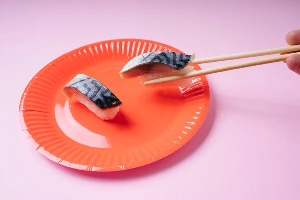 用筷子吃红盘寿司的人 — 图库照片
