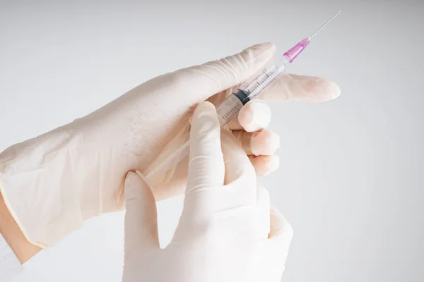 Doctor plastic gloves hand holding using syringe isolate over white background.