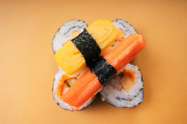 顶部视图 黄底寿司卷上的蛋卷蟹条寿司 — 图库照片