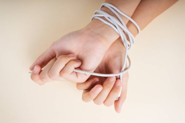Sosyal bağımlılık konsepti. USB kabloyla bağlanmış iki el.