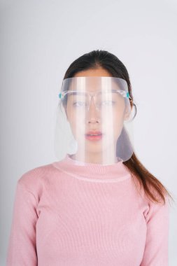 Yeni normal moda portresi. Asya Taylandlı, uzun siyah saçlı, yüz kalkanı takan kadın beyaz üzerine izole edilmiş..