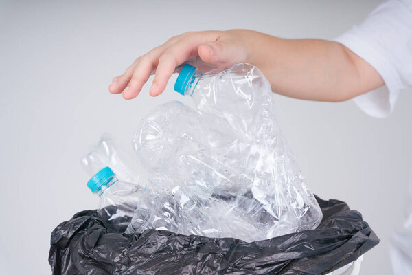 Woman hand putting plastic bottle in resue or recycling in trash rubbish bin.