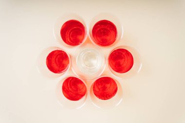 Üst Manzara - Saf tatlı suyun etrafında plastik bardakta kırmızı soda kümesi.