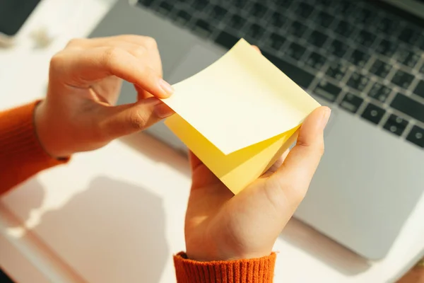 Laptop çalışma masasında not aldığı için öğrenci opem yapışkan not.