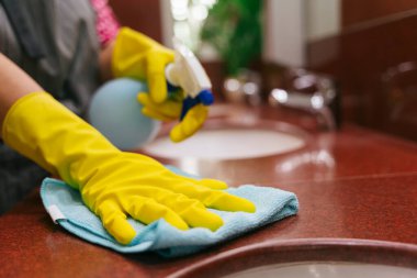 Temizlikçi, deterjan şişesi ve tuvalet lavabosu temizleyicisi kullanıyor. Covid-19 Coronavirus önleme.