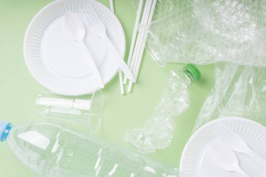 Üst Görünüm - Yeşil arkaplan üzerindeki plastik atık.