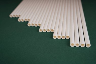 Üst manzara - koyu yeşil arka planda beyaz pipet. Boşluğu kopyala.