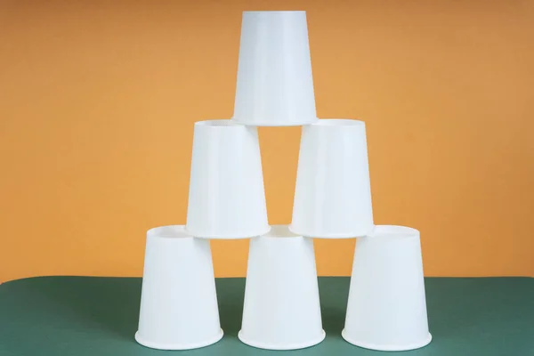 Beyaz kağıt kule. Yeşil masada fincan istifleme oyunu.