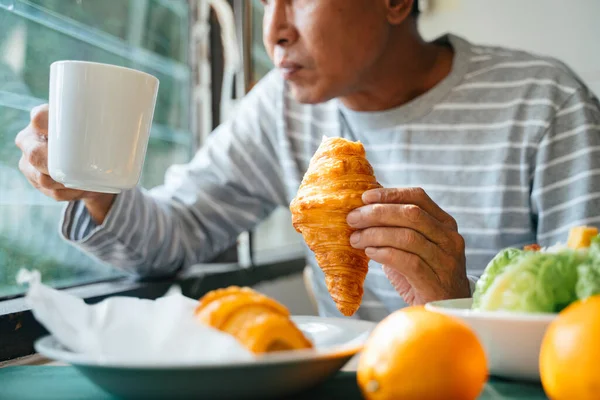 Imagem Cortada Salsicha Xícara Café Nas Mãos Velho Enquanto Ele — Fotografia de Stock