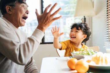 Küçük çocuk kahvaltıları sırasında büyükbabasıyla el vurmuş..