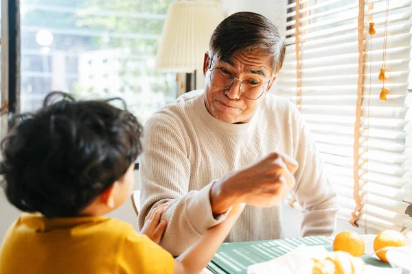 おじいちゃんと孫は食堂で腕相撲をします — ストック写真