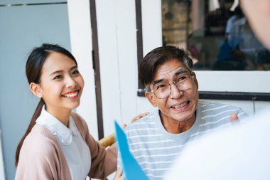 Yaşlı adam, doktoruna sağlık durumunu anlat ve doktora, iyileştiği için iltifat et. Kızı, doktora şükran dolu bir gülümseme versin..