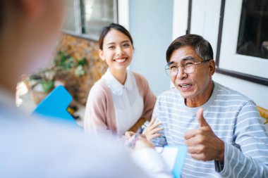 Yaşlı adam, doktoruna sağlık durumunu anlat ve doktora, iyileştiği için iltifat et. Kızı, doktora şükran dolu bir gülümseme versin..